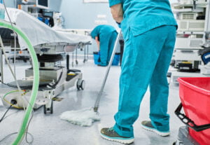 woman cleaning staff mopping the floor of a hospital operating room